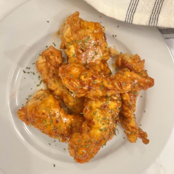 Firecracker Chicken Tenders on a white plate with parsley garnish