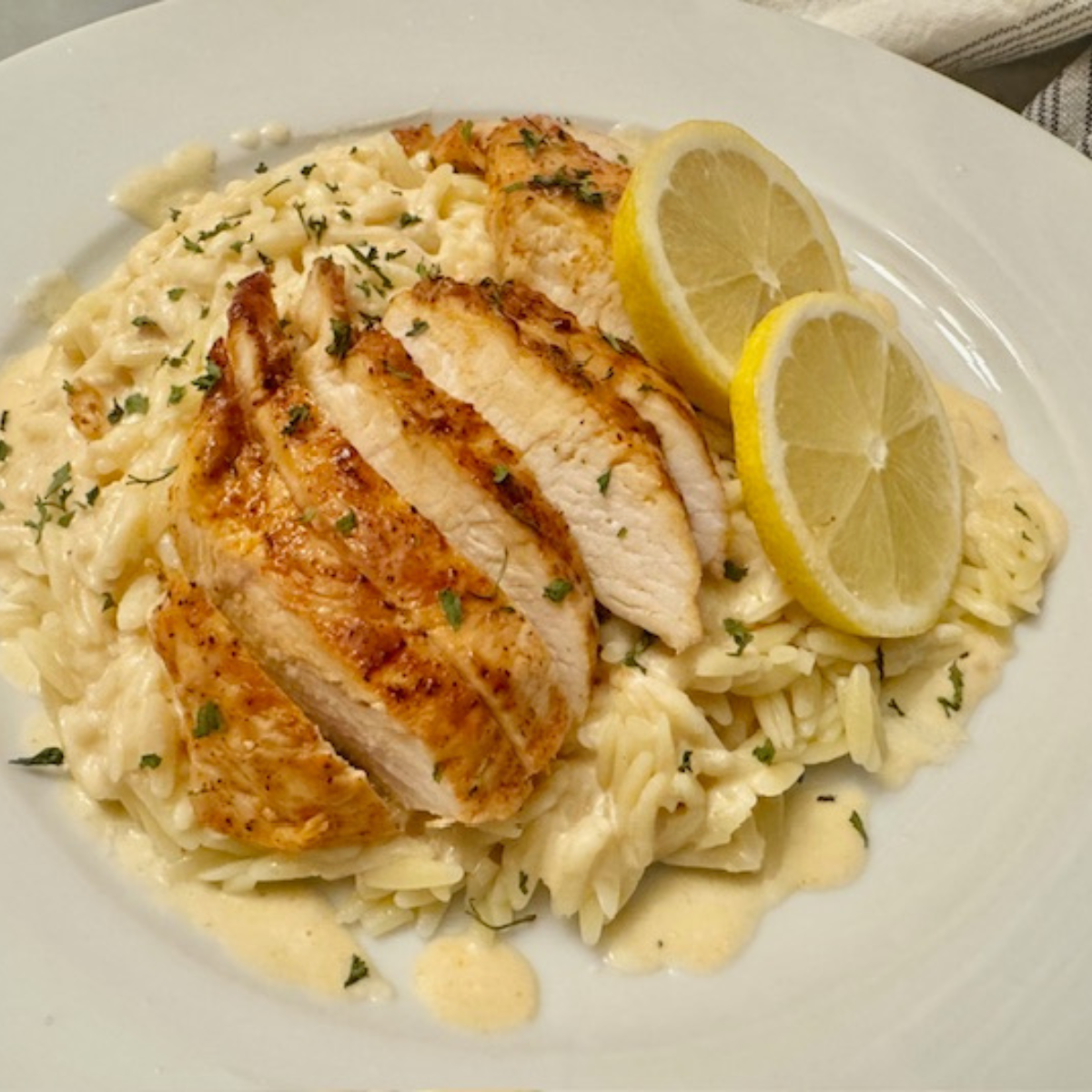 Overhead image of Lemon Chicken With Orzo on a white plate