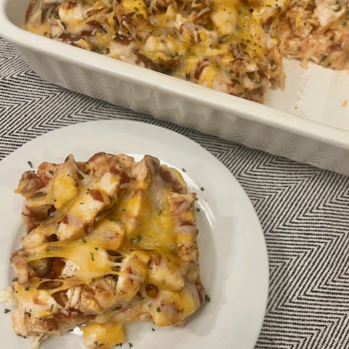 Overhead image of BBQ Chicken and Rice Casserole in a baking dish with a serving on a plate next to it