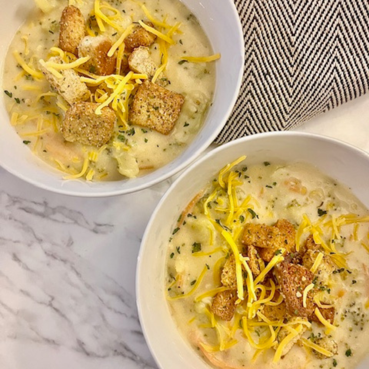 Overhead image of two bowls of broccoli cheddar soup