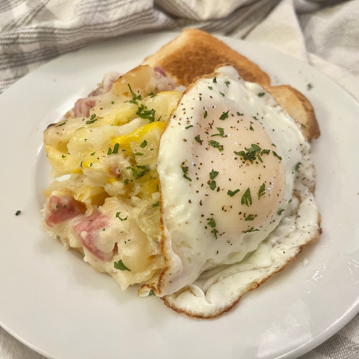 Close up image of Ham and Potato Casserole on a white plate