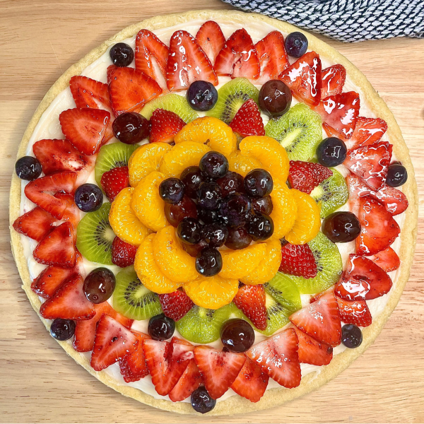 Overhead image of fruit arranged over the top of the sugar cookie crust and sweetened cream cheese frosting