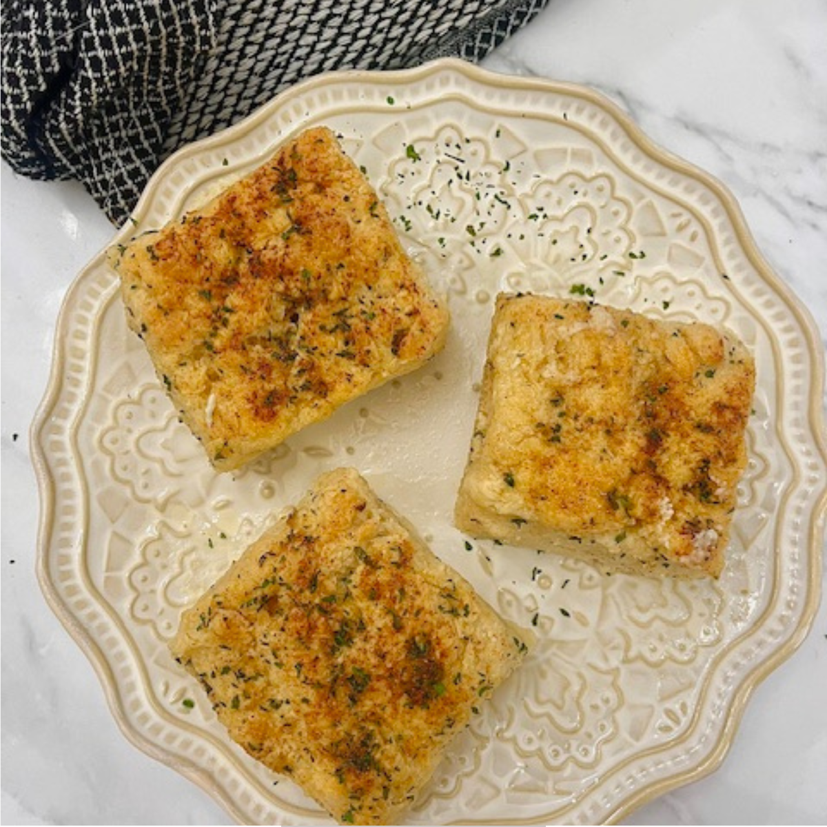 Overhead image of three Garlic Butter Swim Biscuits on a decorative plate