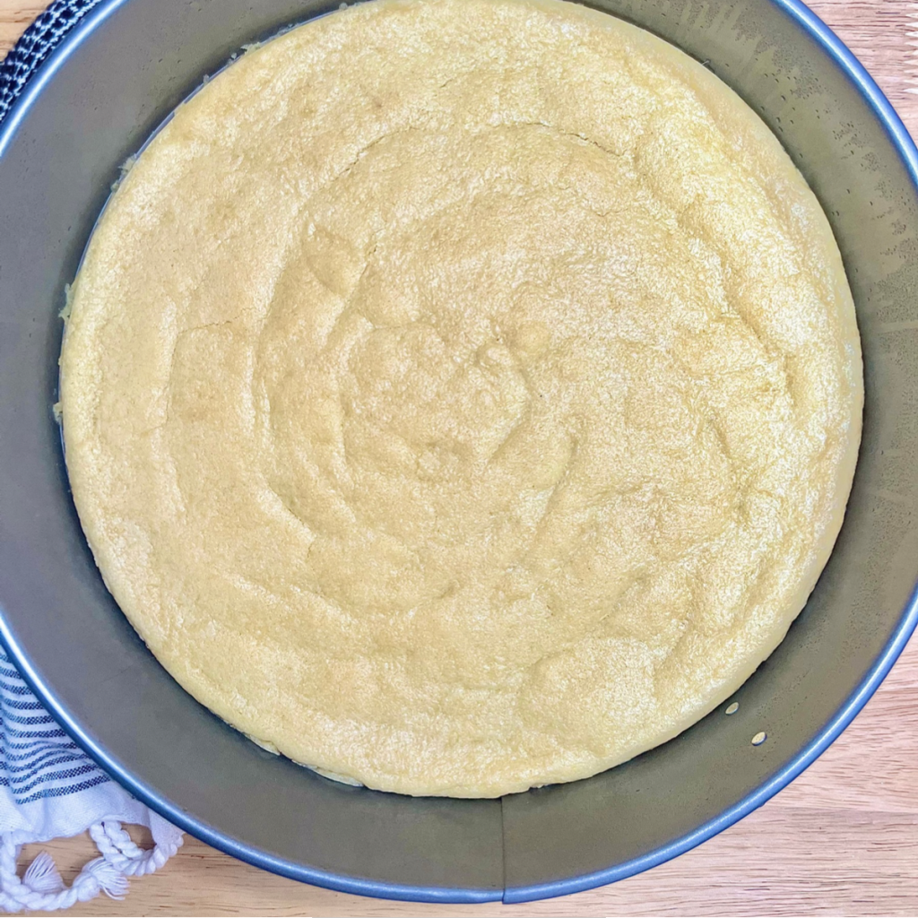 A baked sugar cookie pizza crust in a large springform pan