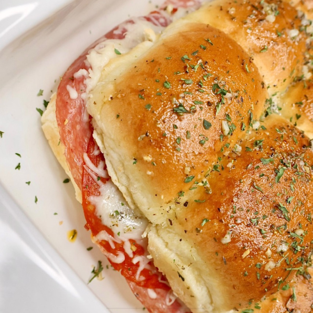 Close up image of baked Italian Sliders in a white baking dish