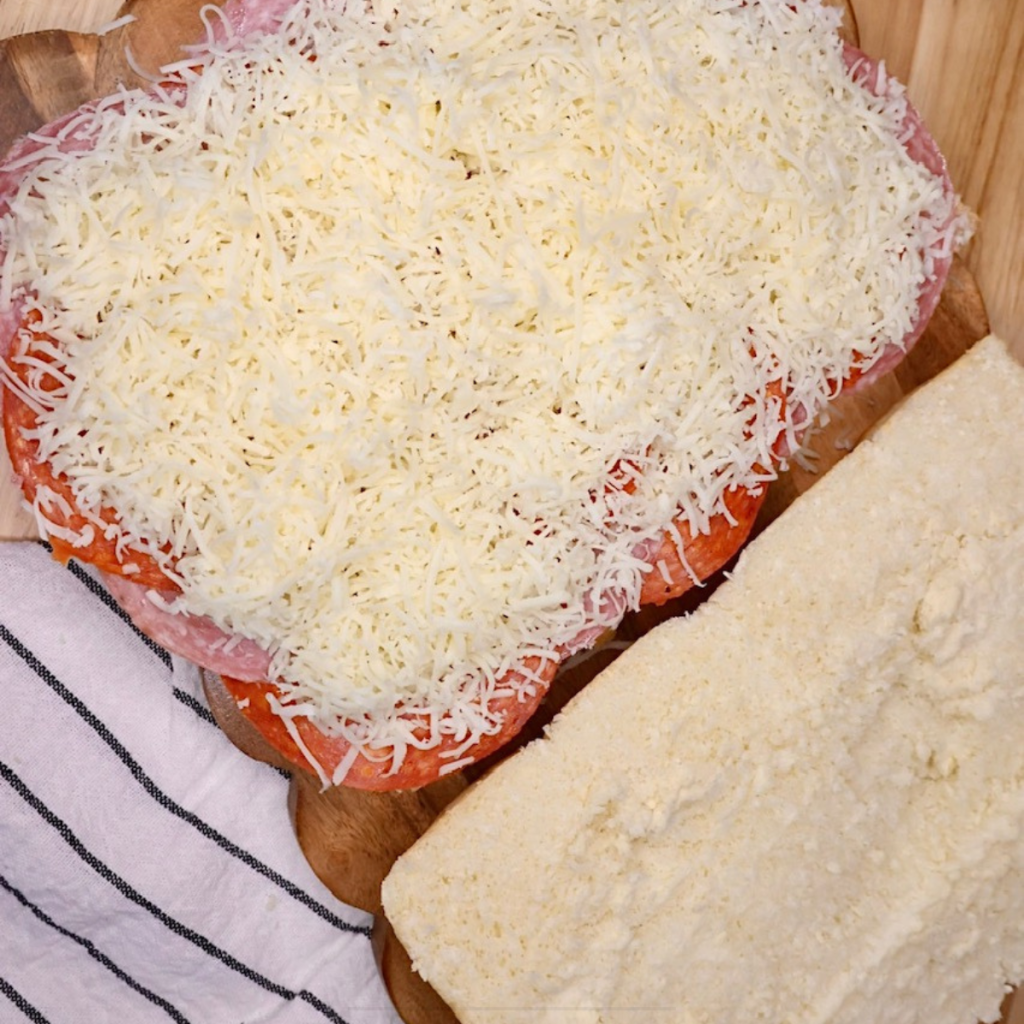 Italian Sliders being assembled with salami, pepperoni, and mozzarella cheese