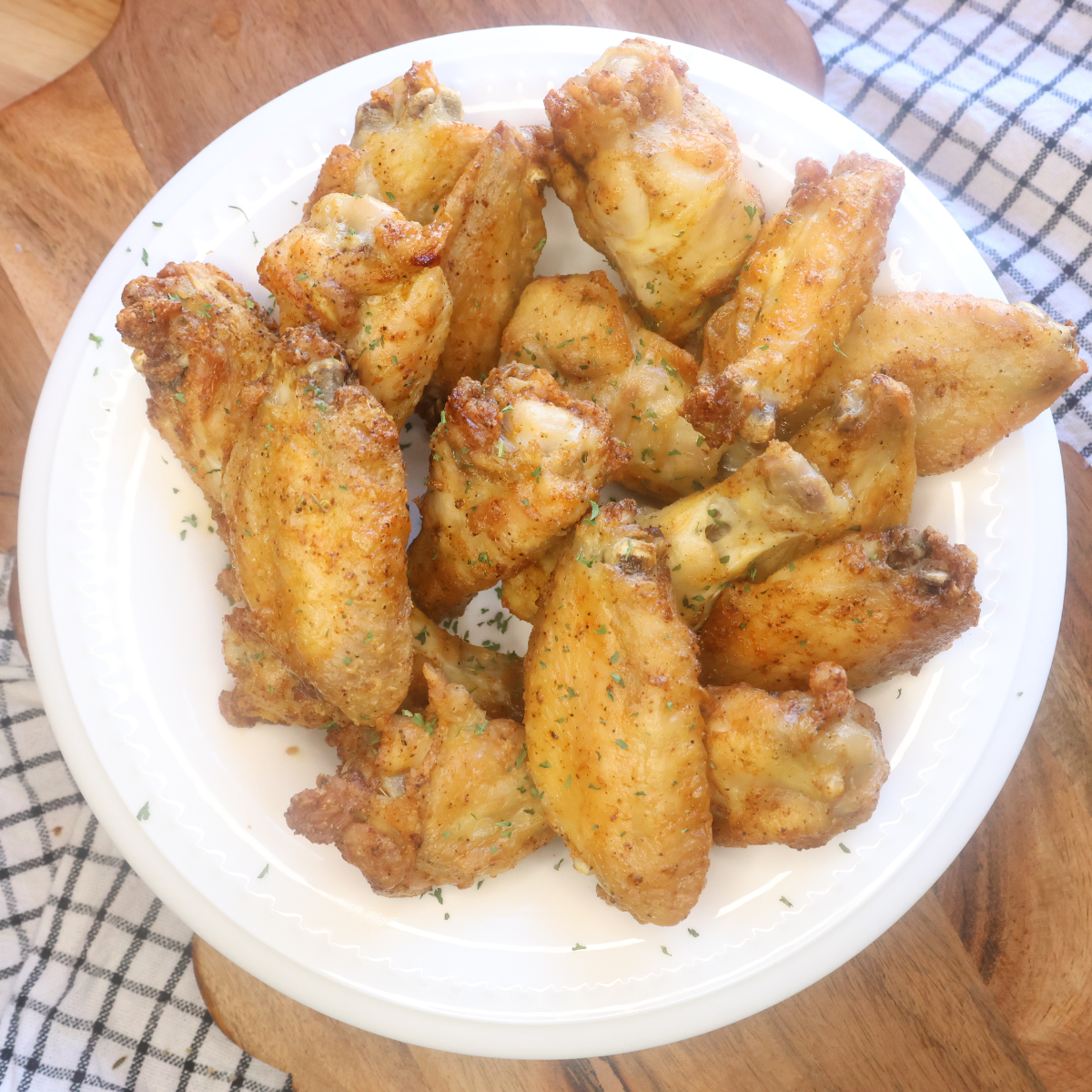 Overhead image of Oven Baked Chicken Wings on a white dish with wooden backdrop