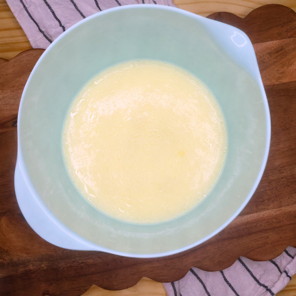 Wet ingredients for mini cornbread muffins in a blue bowl