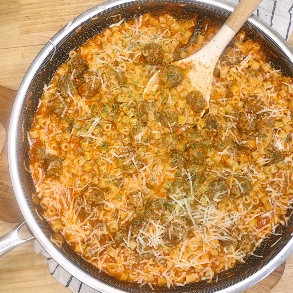 Overhead image of Pasta with Mini Meatballs in a skillet topped with mozarella cheese