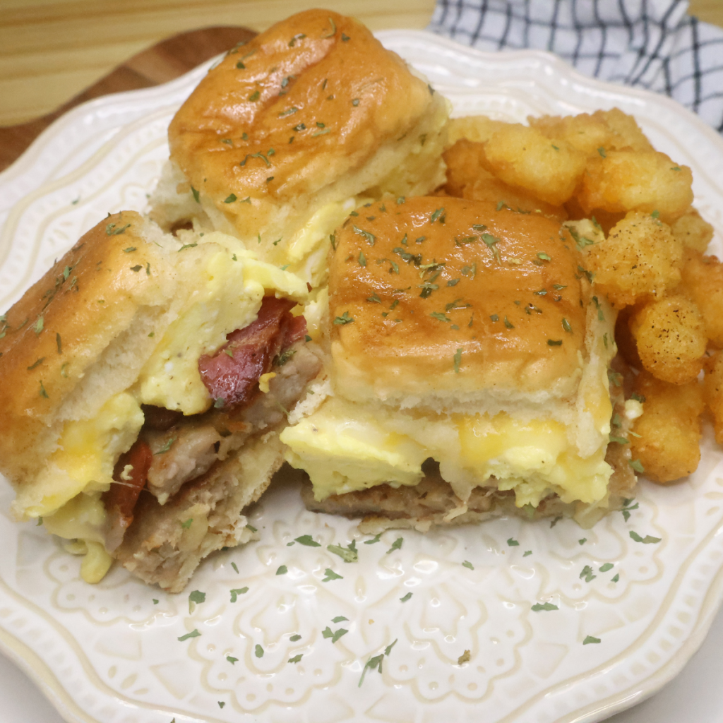 Three Breakfast Hawiian Roll Sliders on a decorative plate with tater tots