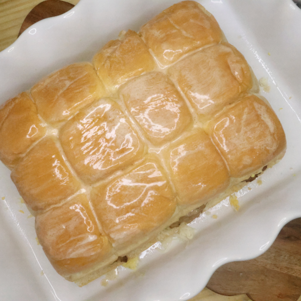 Unbaked breakfast Hawaiian Roll Sliders coated in Texas Roadhouse Butter