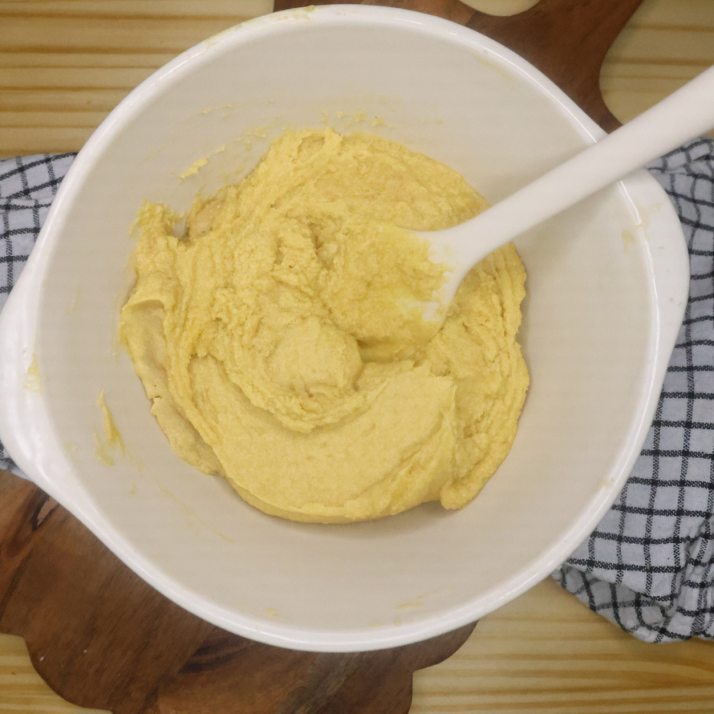 creamed sugars mixed with egg and vanilla in a mixing bowl