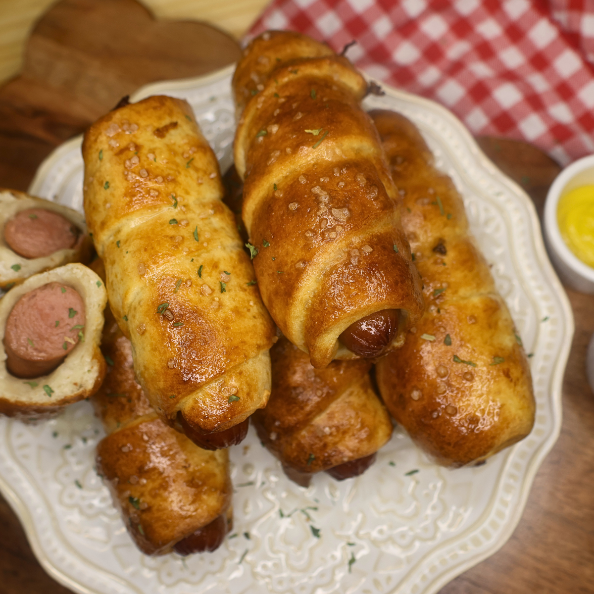 Overhead image of air fryer pretzel dogs stacked on a plate