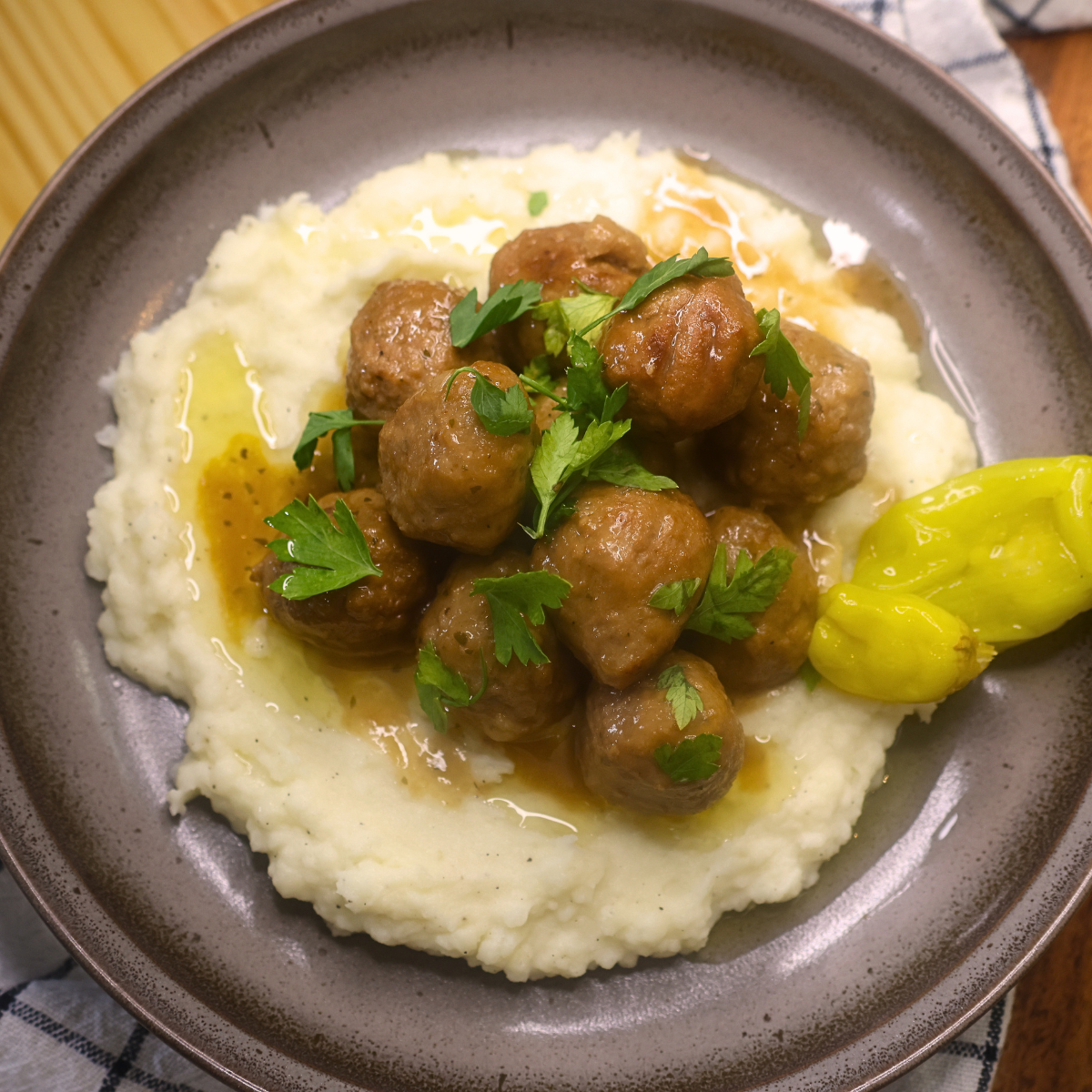 Overhead image of Mississippi Meatballs on a bed of mashed potatoes with garnish