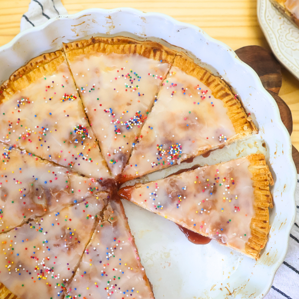 Overhead image of Giant Strawberry Poptart cut into 8 pieces in a large pie plate