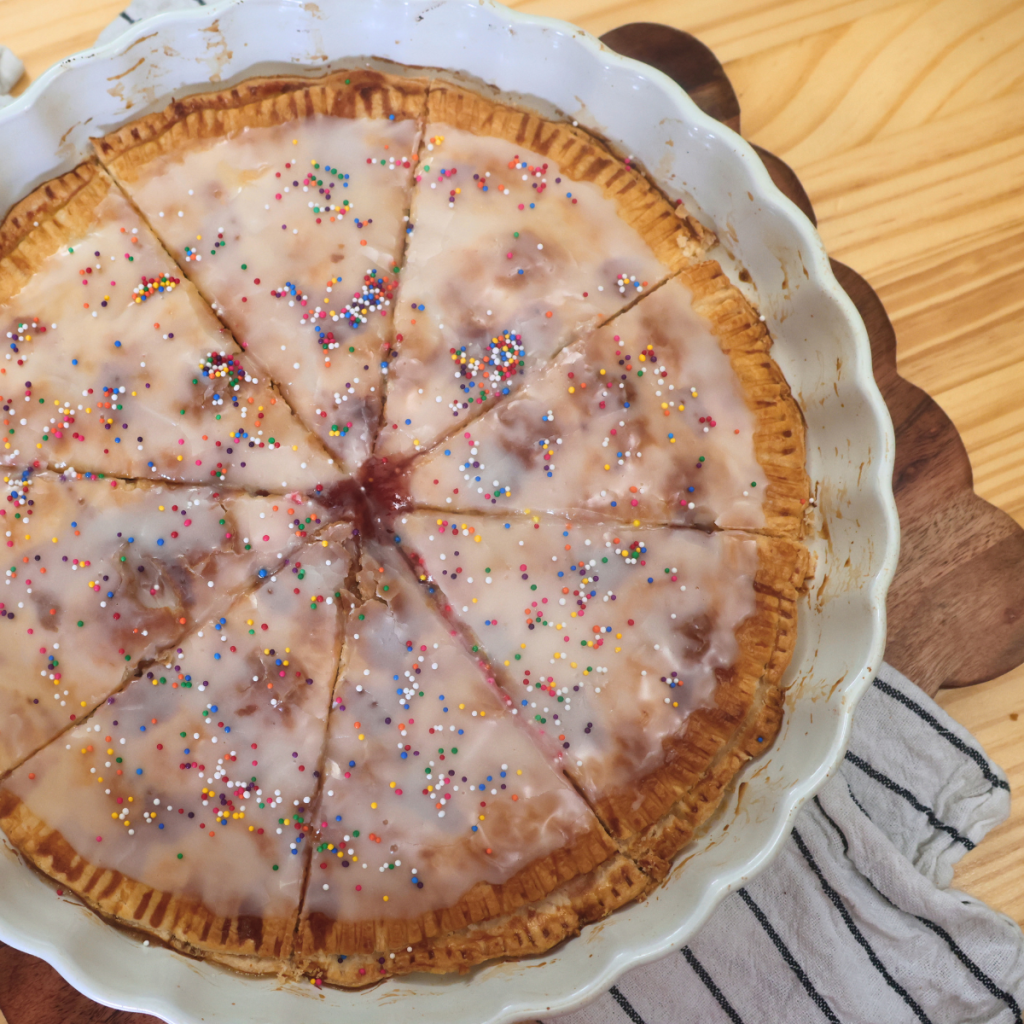 Overhead image of a homemade giant strawberry pop tart in a white pie plate