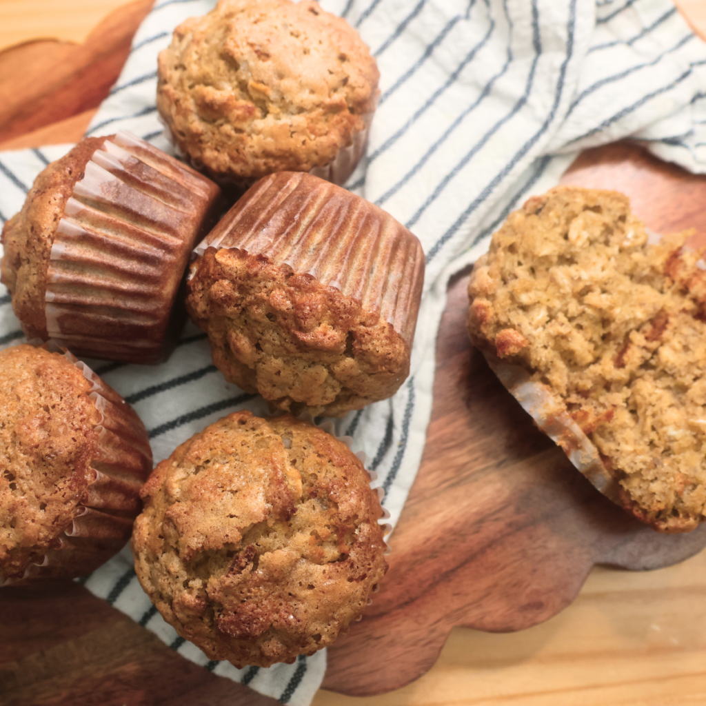Banana Oat Muffins scattered on a rustic surface