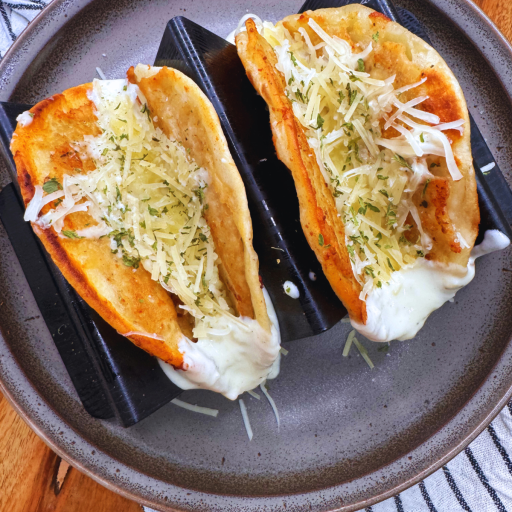 Overhead image of two Chicken Alfredo Smash Tacos in a taco holder on a plate