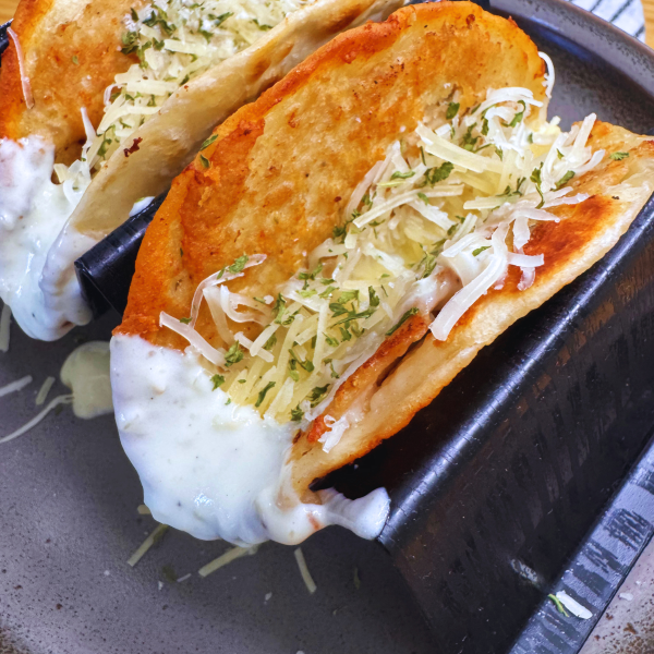 Close up image of two Chicken Alfredo Smash Tacos on a plate